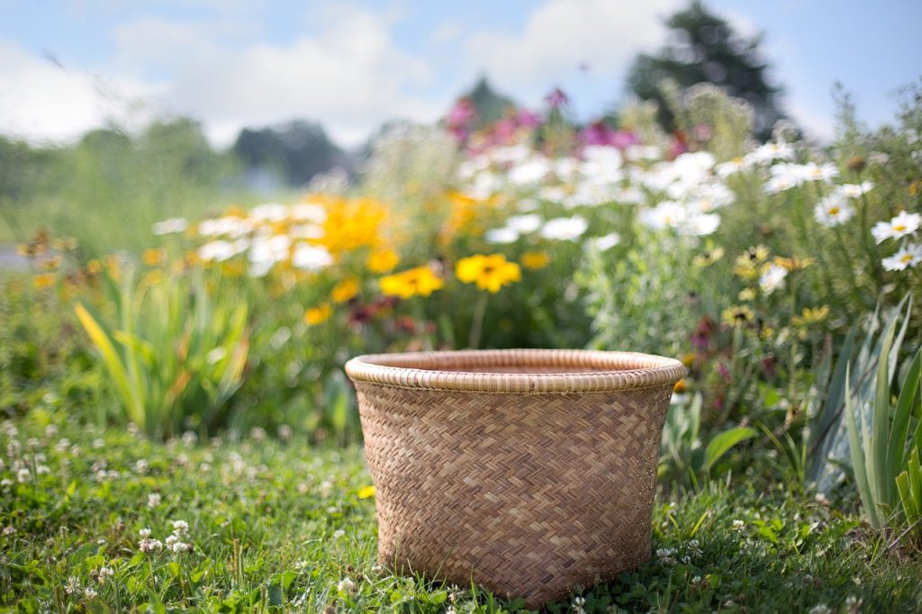 An empty basket against a background of a meadow with wildflowers.